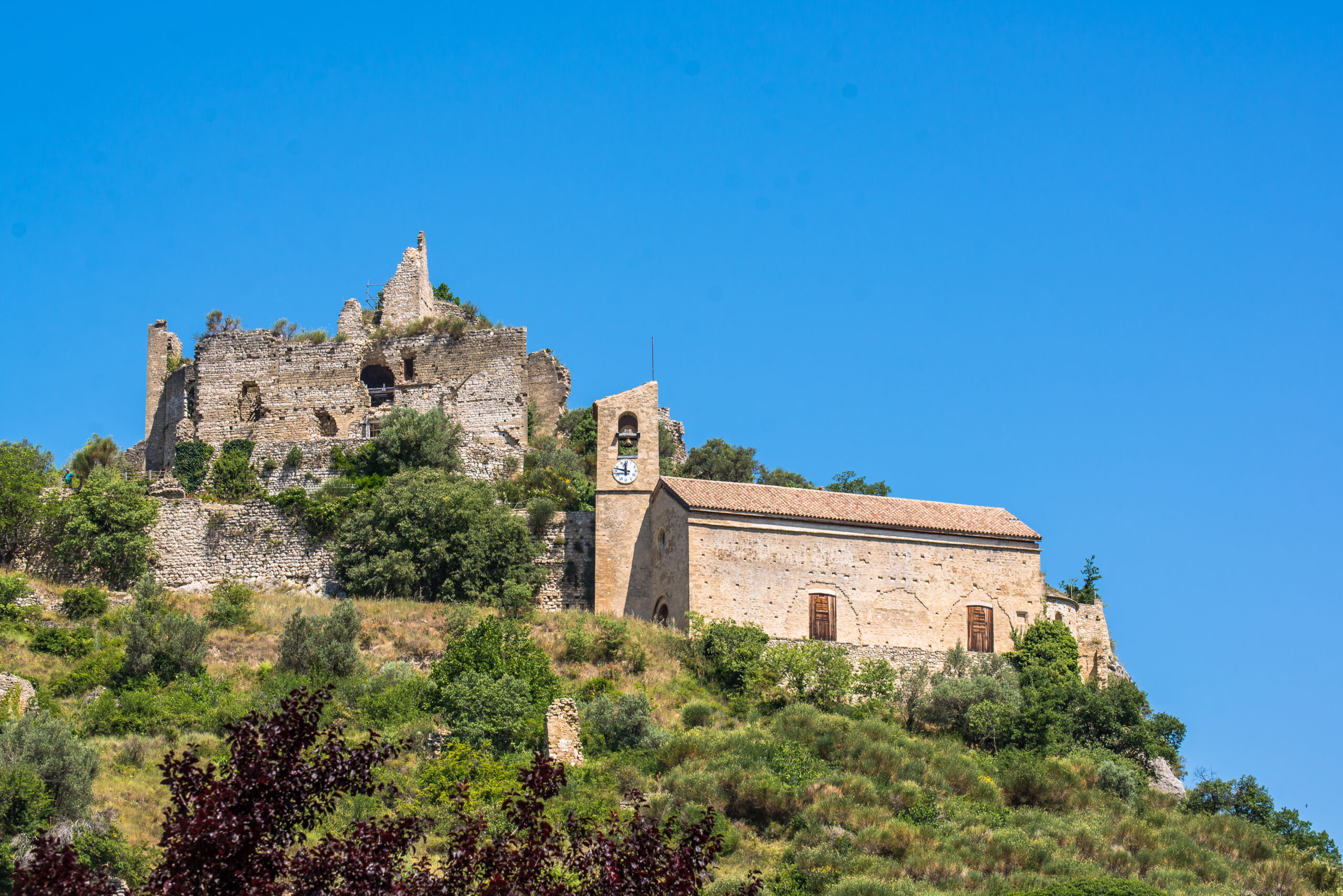 Vue sur le château et l'église d'Entrechaux, perchés sur une colline.