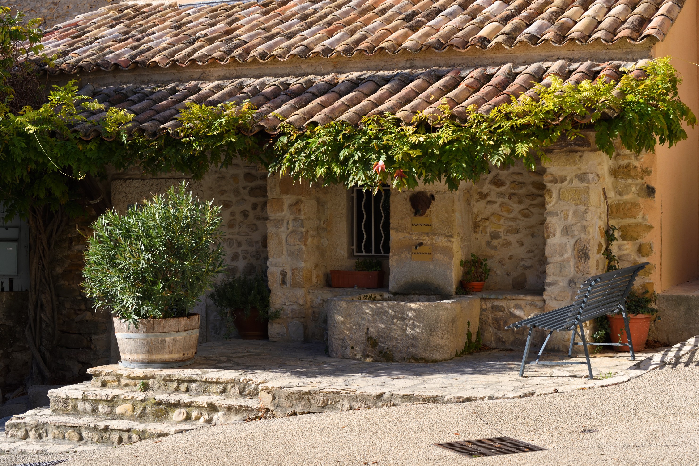 Maison en pierre et fontaine à Roaix