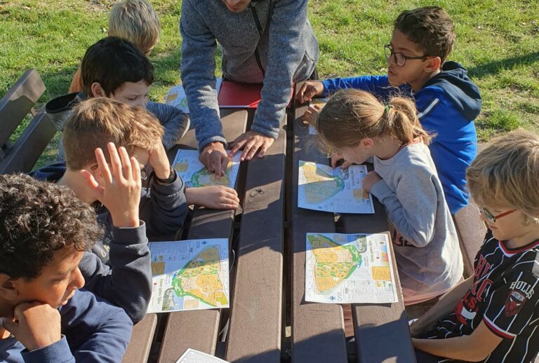Des enfants consultent des cartes lors d'un parcours d'orientation.