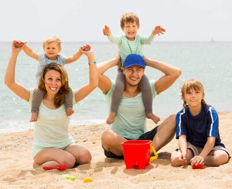 Une famille souriante au bord de la plage.