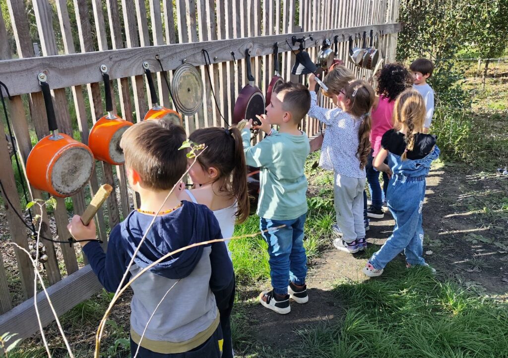 Des enfants de l'accueil de loisirs jouent de la musique avec des instruments insolites.
