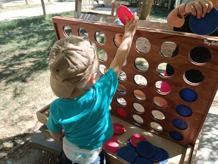 Un enfant joue en plein air avec des jeux en bois.