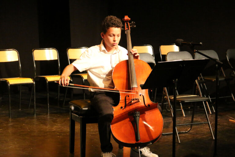 Adolescent jouant du violoncelle à l'école de musique Vaison Ventoux.