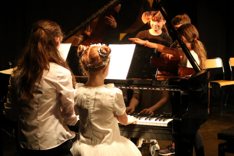 Deux fillettes de dos jouant du piano lors d'une audition