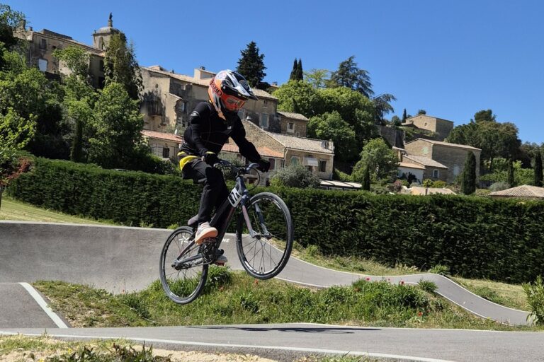 Un adolescent effectue un saut sur une piste de BMX.