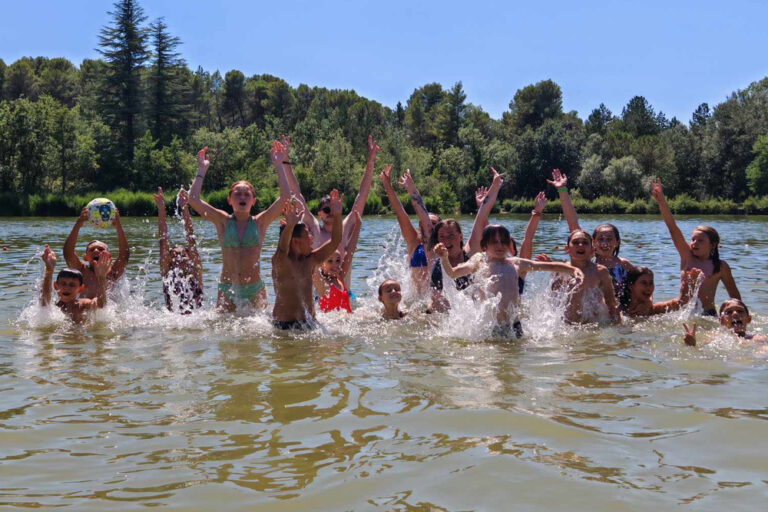 Des enfants de l'accueil de loisirs prennent la pose dans l'eau lors d'une sortie rivière.
