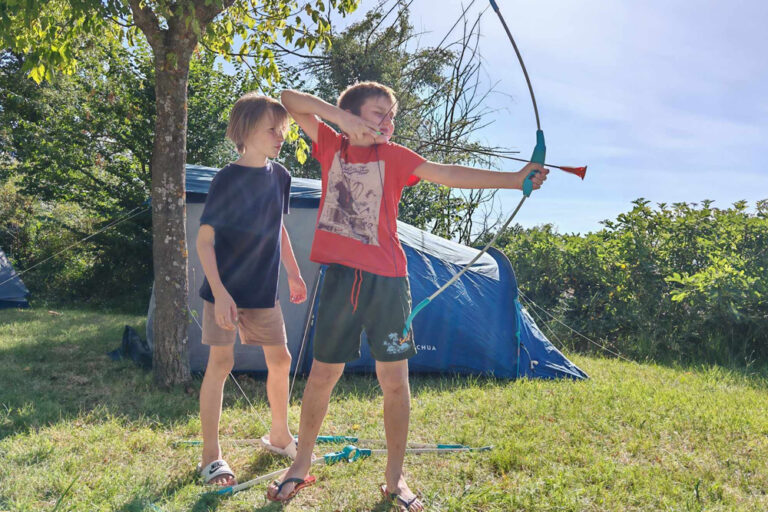 Deux garçons s'exercent au tir à l'arc.