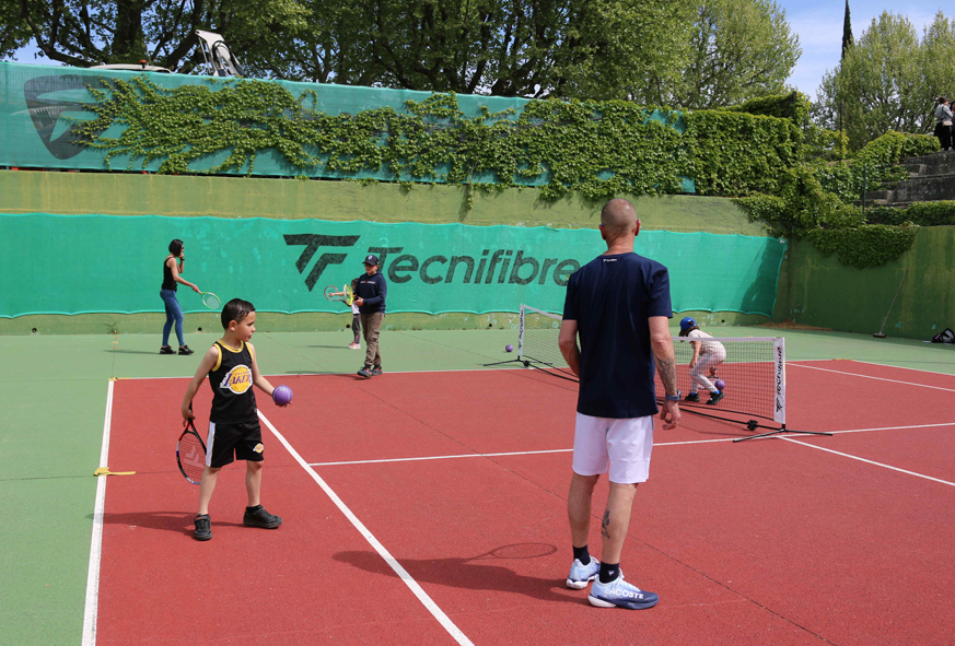Des adultes initient des enfants au tennis-ludique avec de grosses balles.