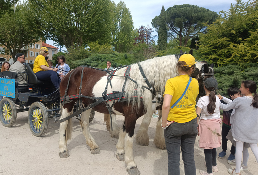 Des enfants et des parents montent dans une calèche tirée par des chevaux.