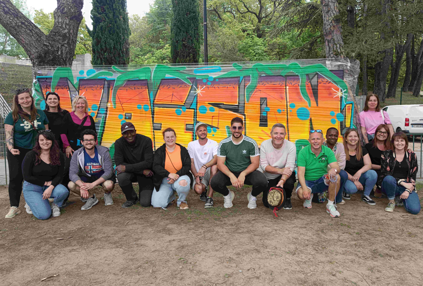 Les équipes des services enfance-jeunesse de la Communauté de communes Vaison Ventoux posent devant un graff avec l'inscription "Vaison".