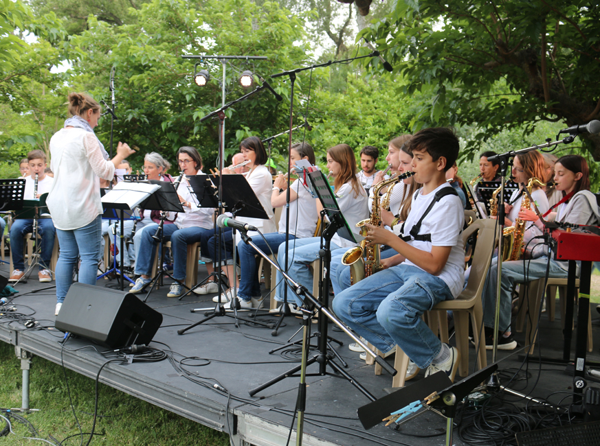 De jeunes musiciens jouent sur scène en extérieur.