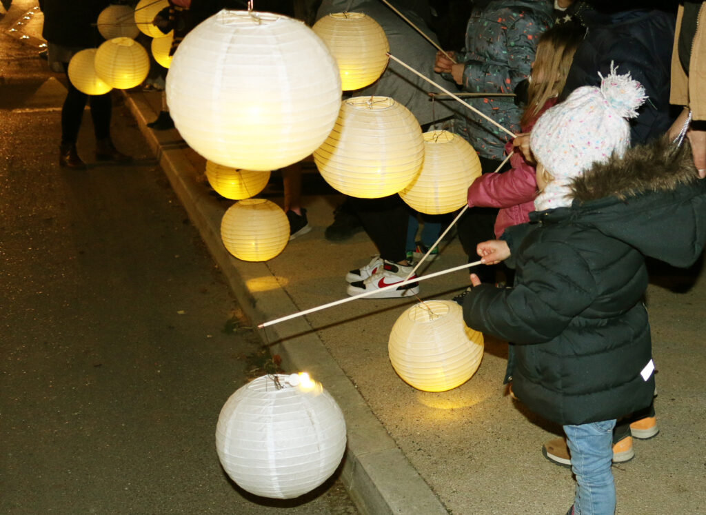 Plusieurs enfants tiennent des lampions ronds lors d'un défilé des Automnales.