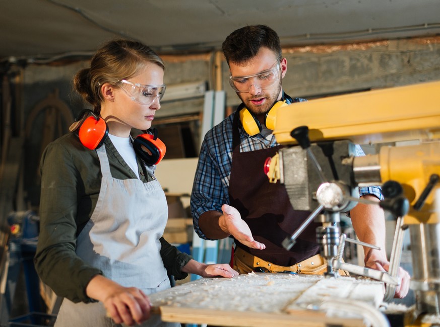 Deux jeunes travaillent autour d'un établi.