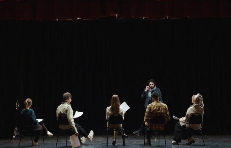Atelier théâtre. Plusieurs personnes répétant sur scène.