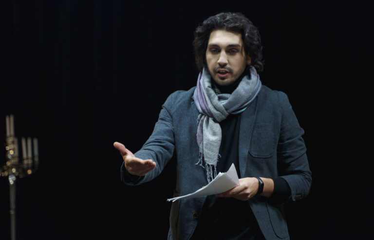 Comédien déclamant un texte au théâtre.